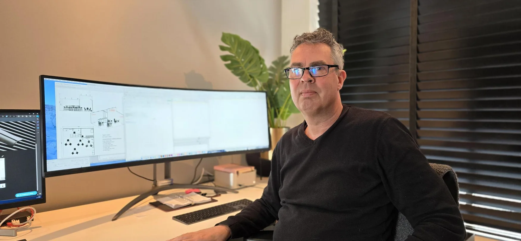 Specialist van Risk Visuals aan de werkplek met technische tekeningen